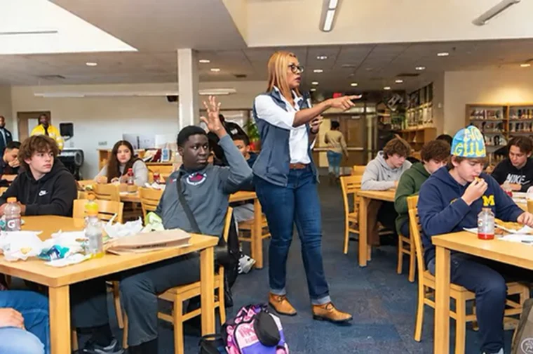 Ms. Wiley leads a Financial Foundations session while a student raises his hand